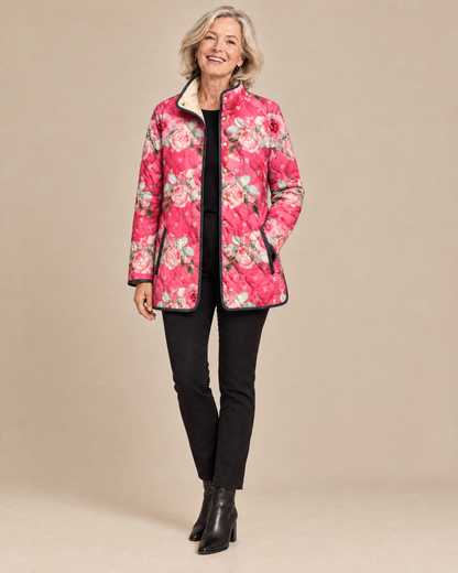Woman wearing the Freya pink floral print quilted jacket, front view